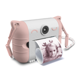 Cute pink and white toy camera with cat ears, printing a black and white photo of a child smiling. The design is playful and whimsical.