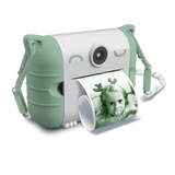 Cute white and mint green instant camera with cat ears prints a photo of a child making a playful face. The design is whimsical and fun.