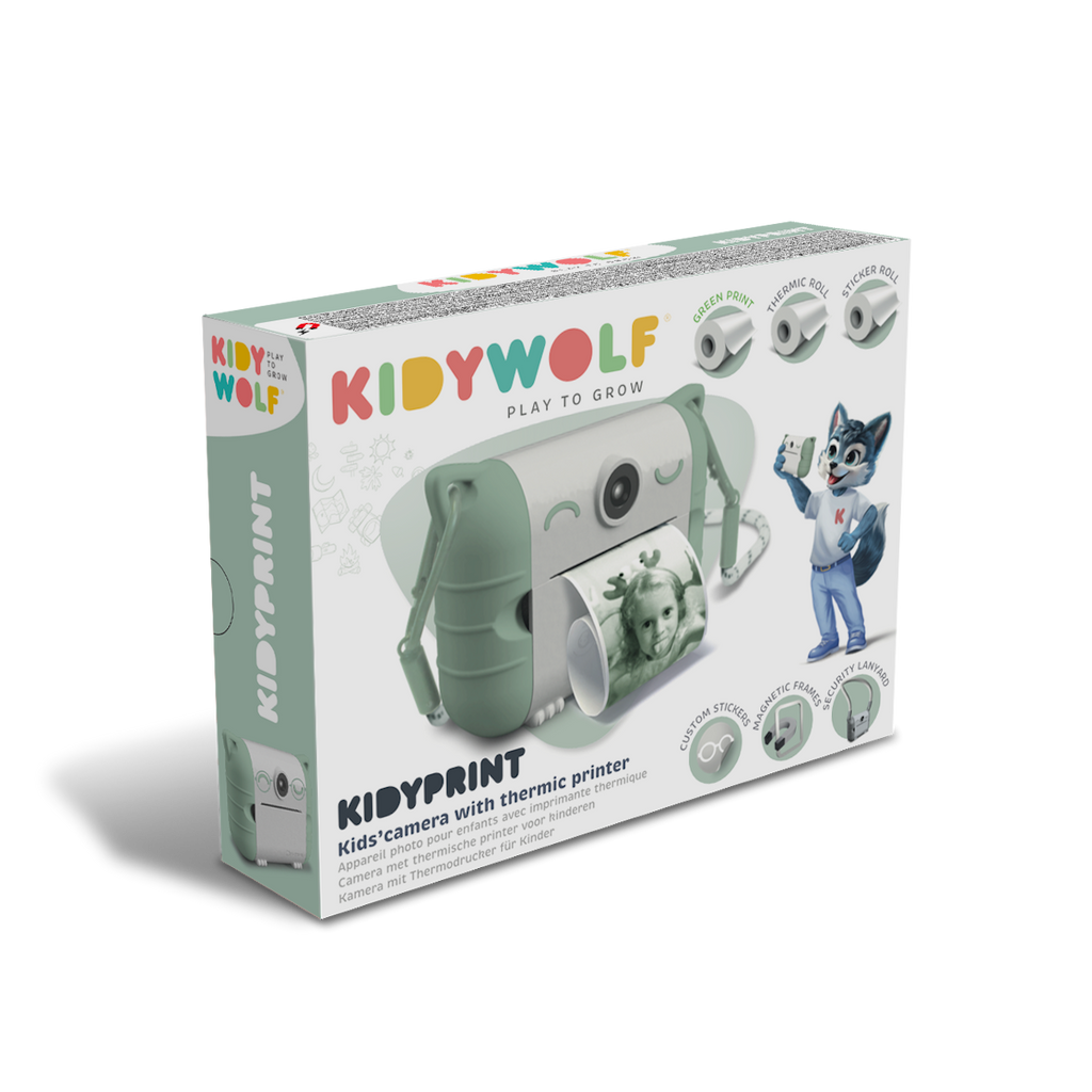 Kid's thermic printer camera packaging. Features a green camera printing a photo of a girl. Includes a cartoon wolf mascot. Bright and playful design.