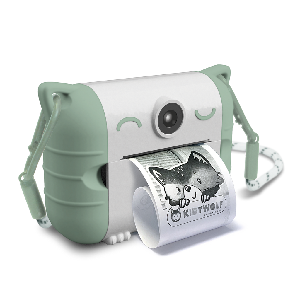 Cute white and mint green instant camera with cat ears prints a photo of a child making a playful face. The design is whimsical and fun.