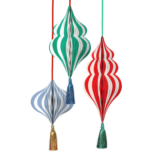 Three striped honeycomb paper ornaments in green, red, and light blue hanging with tassels.