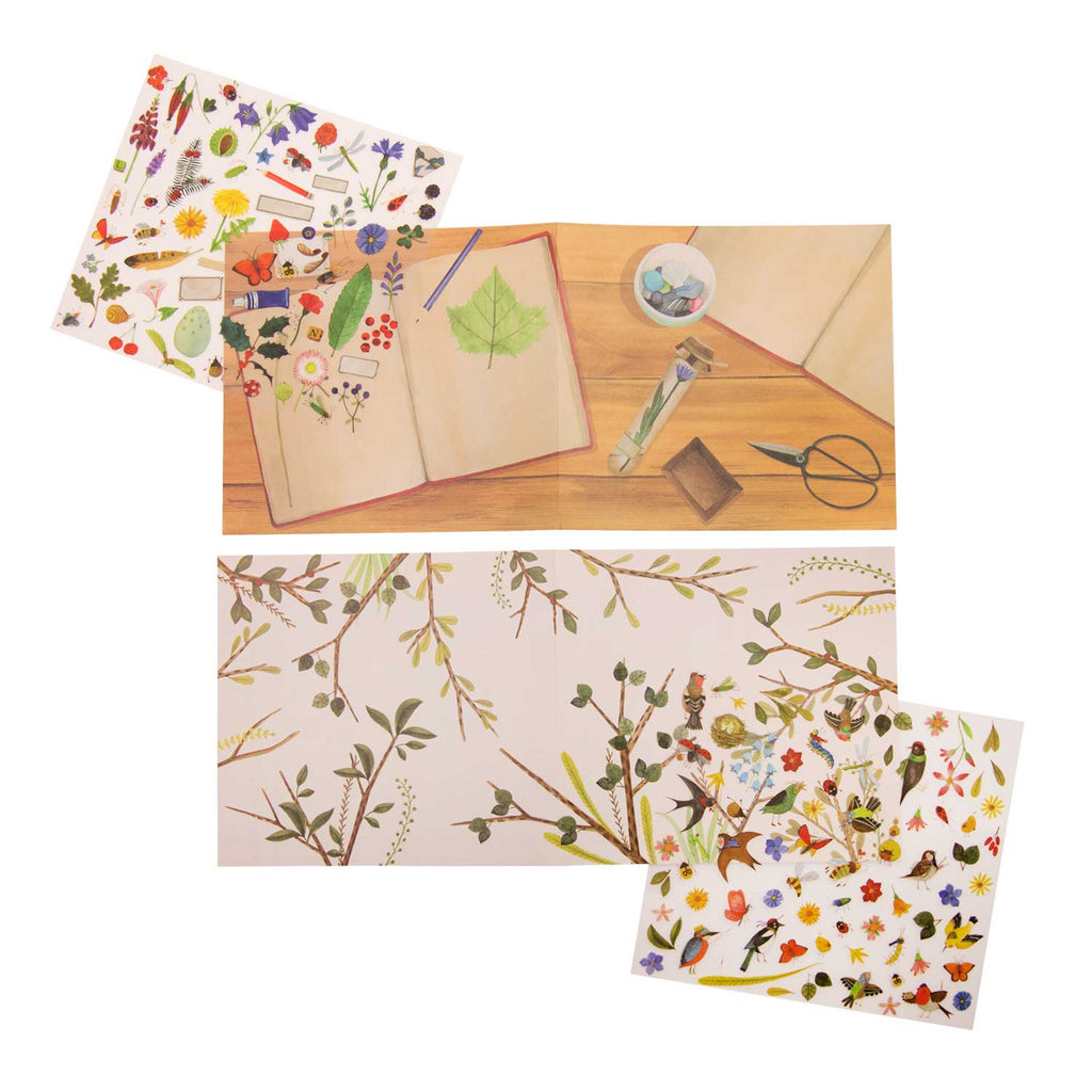 An open scrapbook on a wooden table features pressed flowers and leaves. Surrounding it are sheets with colorful botanical stickers and illustrations, evoking a creative and nature-inspired mood.