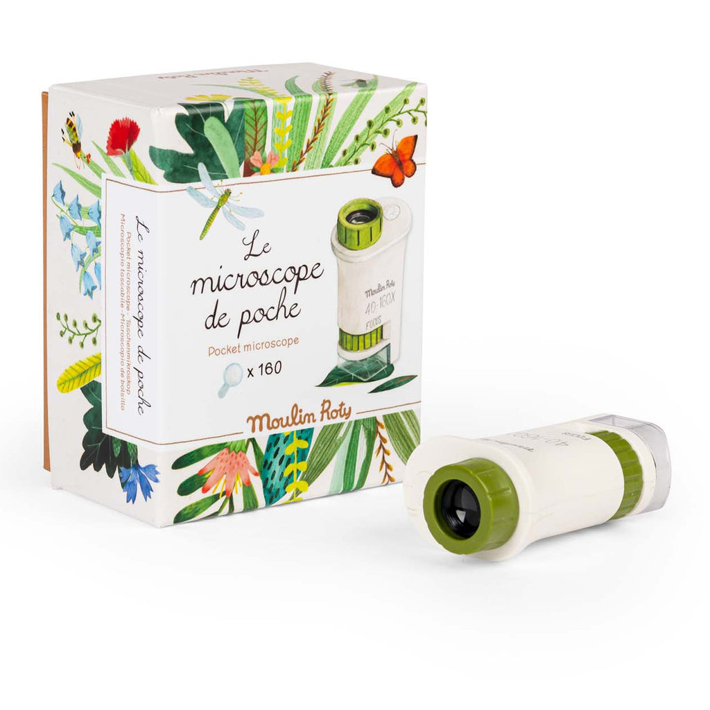 A pocket microscope with green accents is in front of a decorative box featuring colorful leaves, a dragonfly, and a red butterfly.