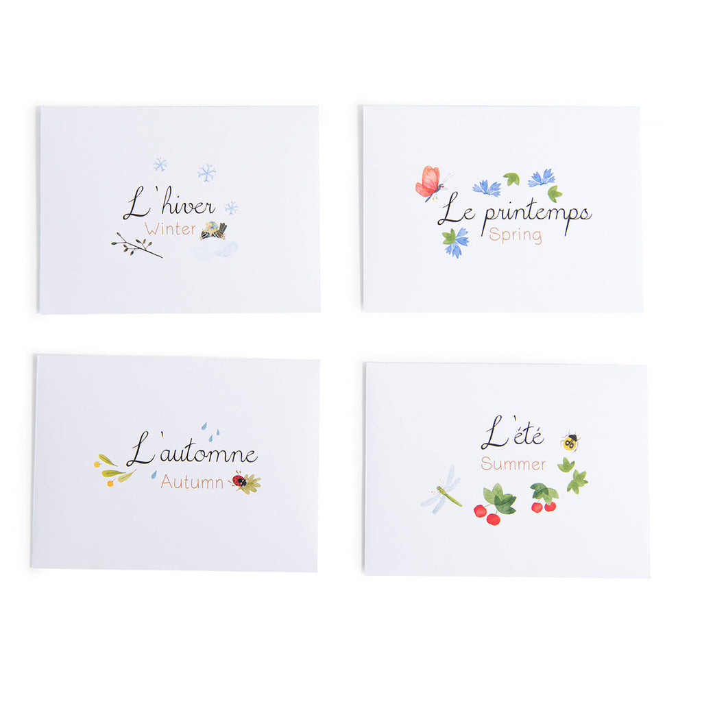 Four white cards depict the seasons in French and English. Each card features seasonal illustrations like snowflakes, flowers, leaves, and insects.