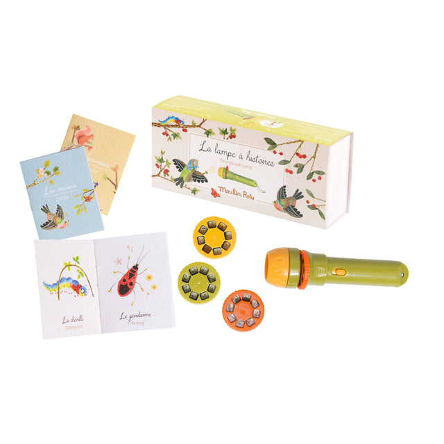 Children's storytelling kit with a green and orange flashlight, three colorful story discs, illustrated books, and vibrant packaging. Playful and imaginative.