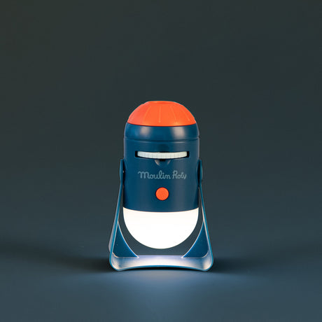 Moulin Roty Les Explorateurs space projector toy glowing in the dark in navy blue and orange rocket design for kids.
