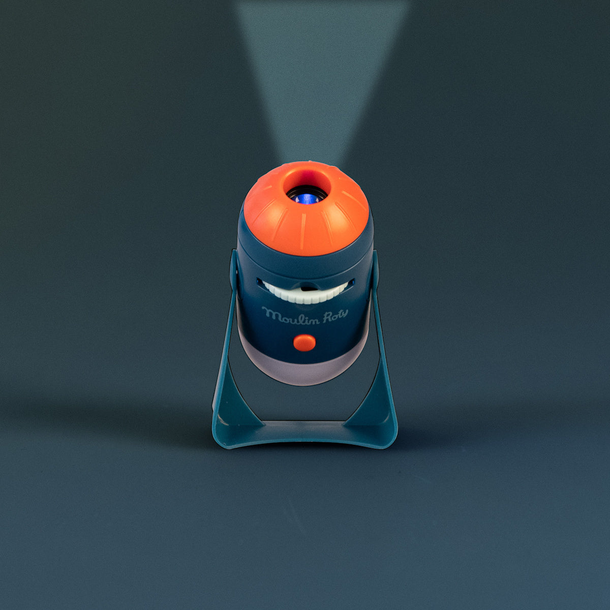 Moulin Roty Les Explorateurs space projector toy projecting light beam upward in navy blue and orange rocket design.