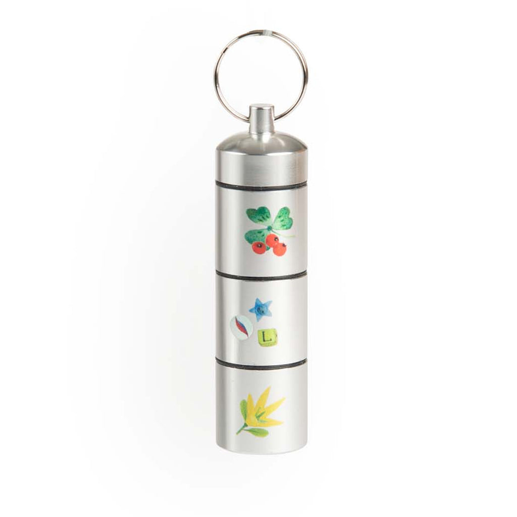 Silver cylindrical container with a keyring, featuring colorful botanical and star decals. The design is playful and vibrant.