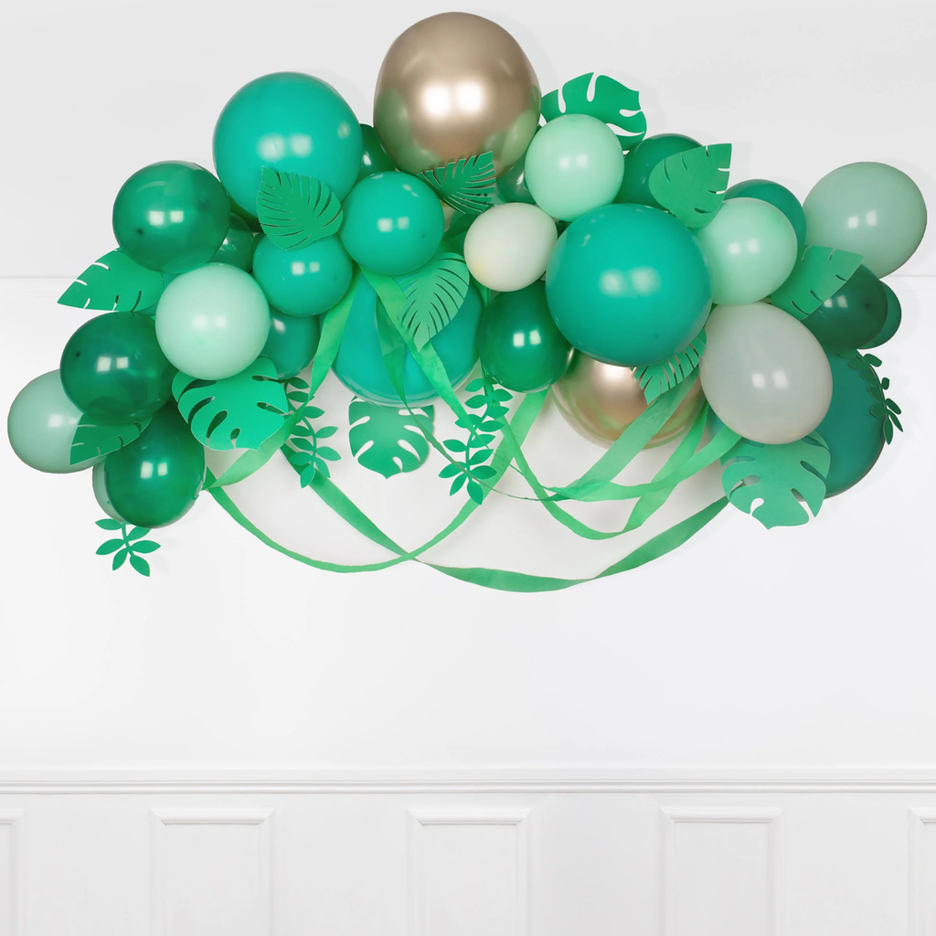 A festive balloon arch featuring green balloons and leafy accents, perfect for adding a natural touch to party decor or outdoor events.