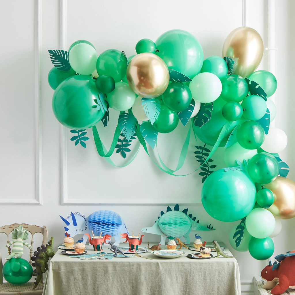 A festive balloon arch featuring green balloons and leafy accents, perfect for adding a natural touch to party decor or outdoor events.