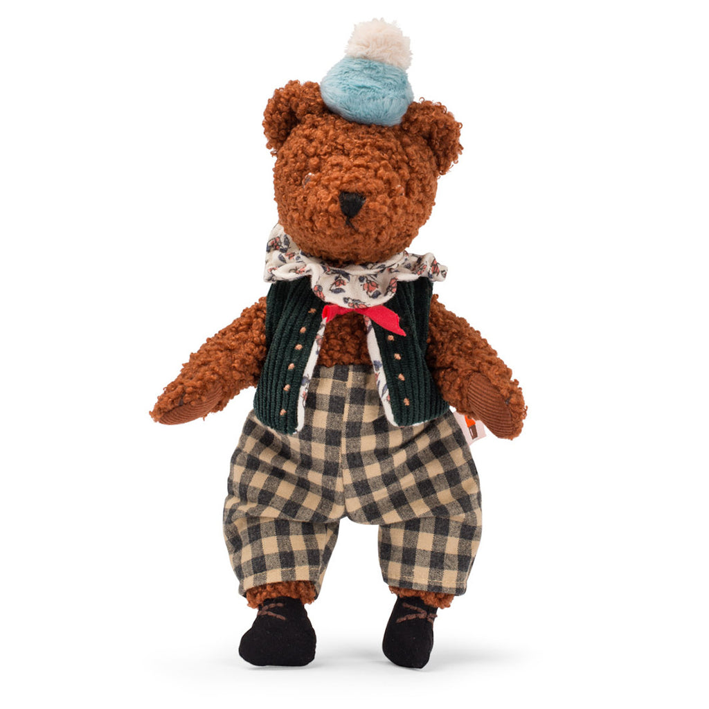 Cute brown teddy bear wearing a blue and white pom-pom hat, a floral scarf, green vest, and plaid pants, exuding a vintage charm.