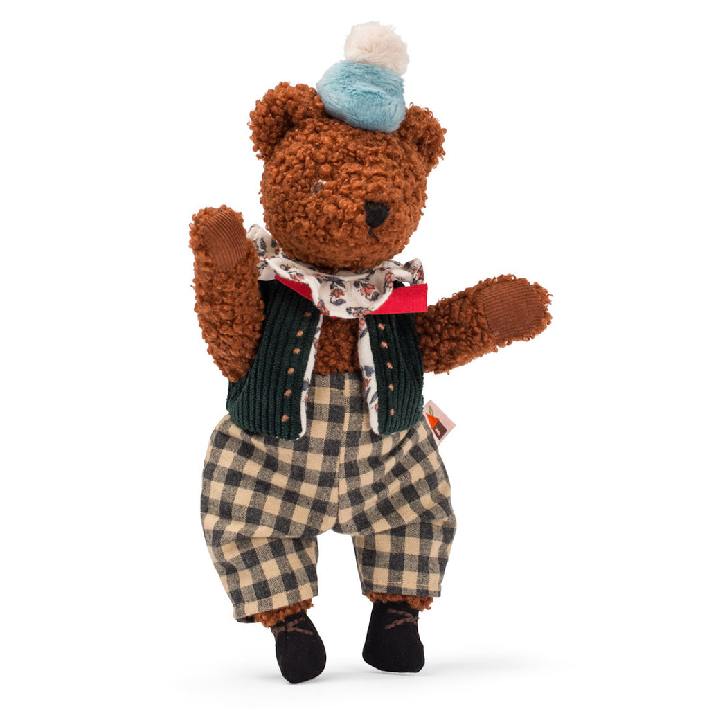 Cute brown teddy bear wearing a blue and white pom-pom hat, a floral scarf, green vest, and plaid pants, exuding a vintage charm.