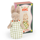 Here's a suitable alt text for the image:

"Plush bunny toy in a white and green checkered dress with heart details, standing in front of a matching decorative box labeled 'Bébé Nine'."