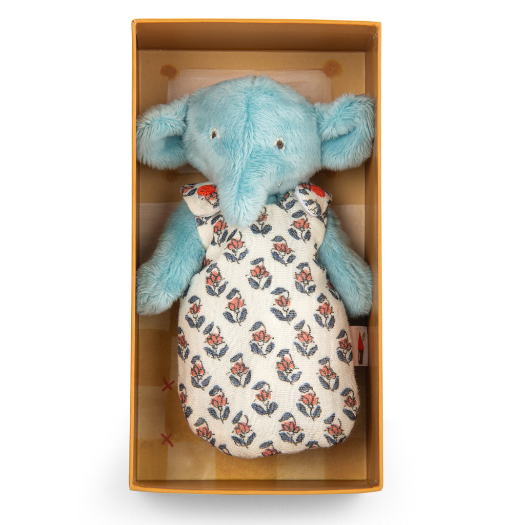 A plush toy elephant with light blue fur, wearing a patterned cloth dress with red and blue floral design, conveying a cute and gentle tone.