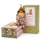Moulin Roty Emile small bear plush toy sitting on its illustrated gift box, next to the main green packaging.