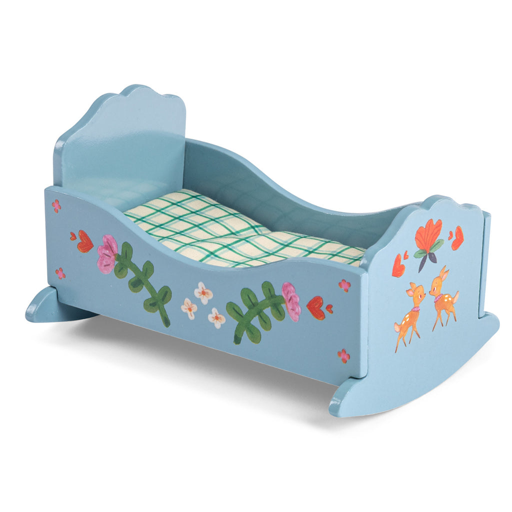 Blue wooden toy bed with floral and deer designs, featuring a grid-patterned mattress. The bed has a playful, whimsical charm.