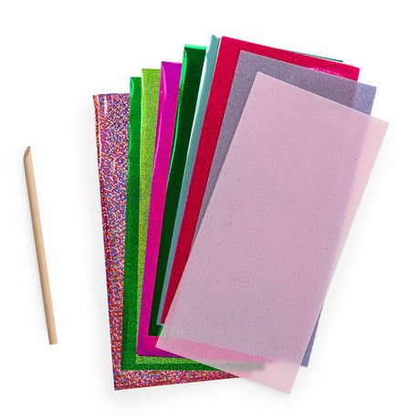 Colorful metallic foil sheets and tracing paper with a wooden stylus tool for crafts.