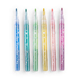 Set of six colorful glitter markers lined up horizontally on a white background for arts and crafts.