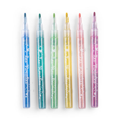 Set of six colorful glitter markers lined up horizontally on a white background for arts and crafts.