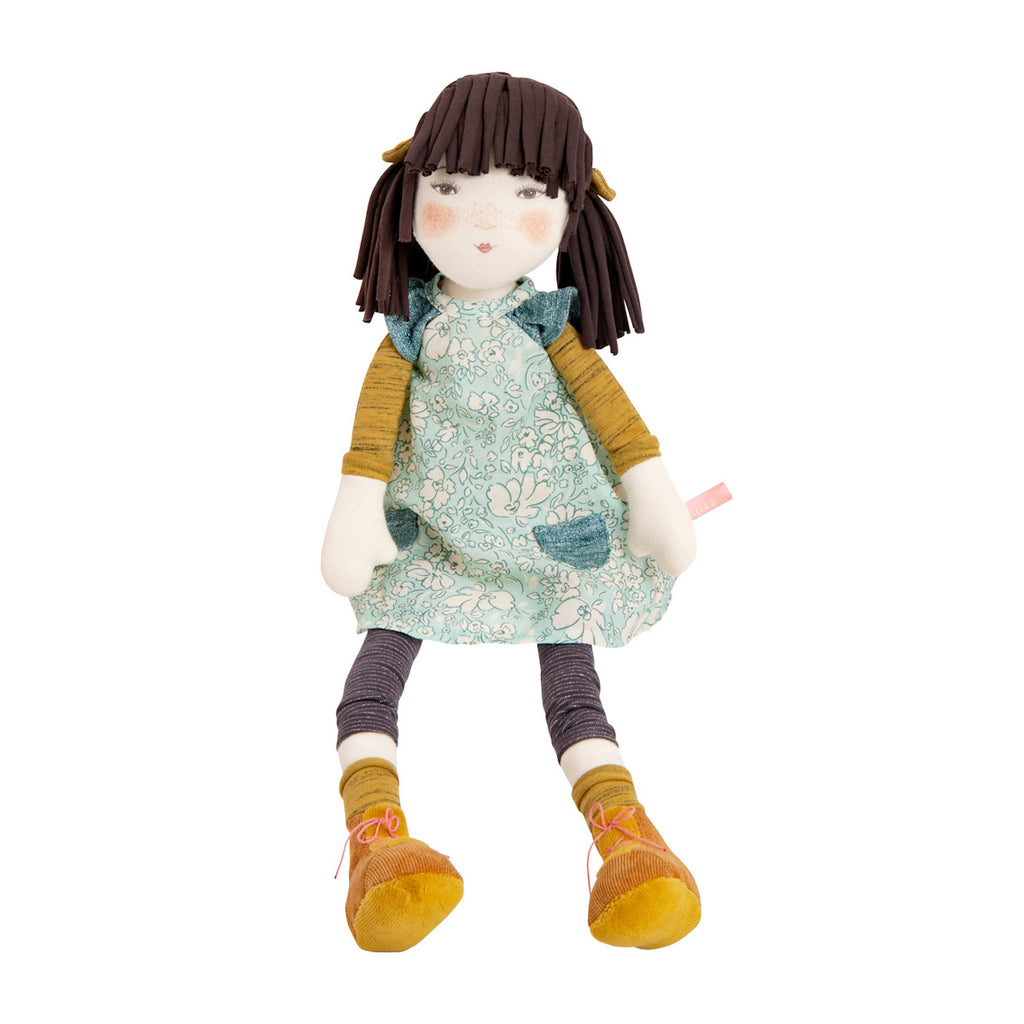 Soft fabric doll with brown hair, wearing a green floral dress, yellow socks, and orange shoes. The doll has a calm expression with rosy cheeks.