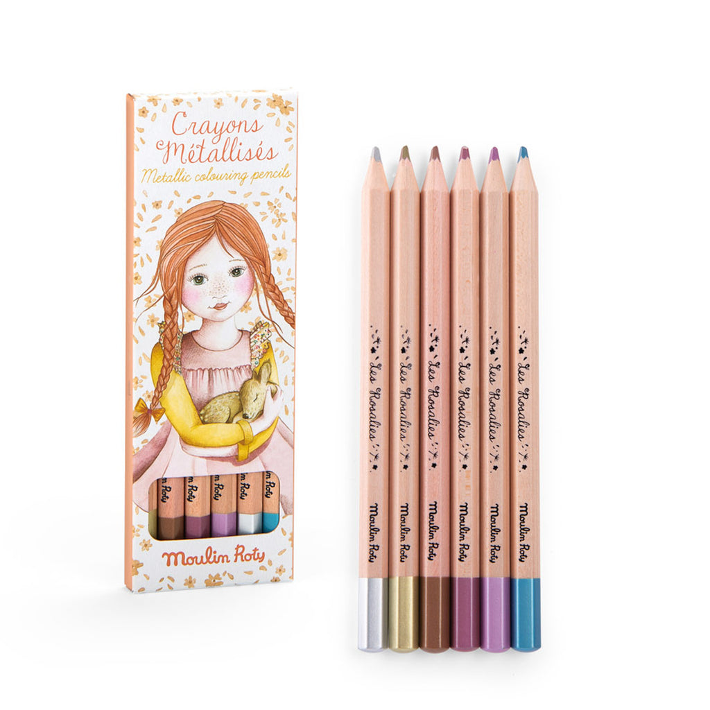 A set of six metallic coloring pencils stands next to its box, featuring a girl with red hair holding a yellow toy. The tones are warm and whimsical.
