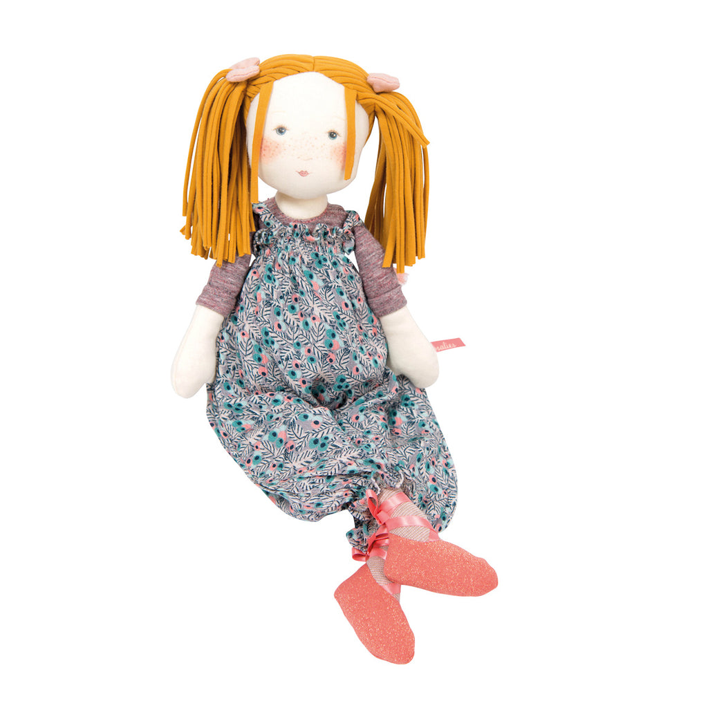 Soft doll with orange yarn hair and blush cheeks, wearing a floral dress and pink socks. The doll's expression is gentle and comforting.