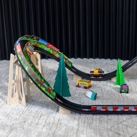Candylab toy cars racing on a wooden track with banked turns and stylized pine trees on a rug.