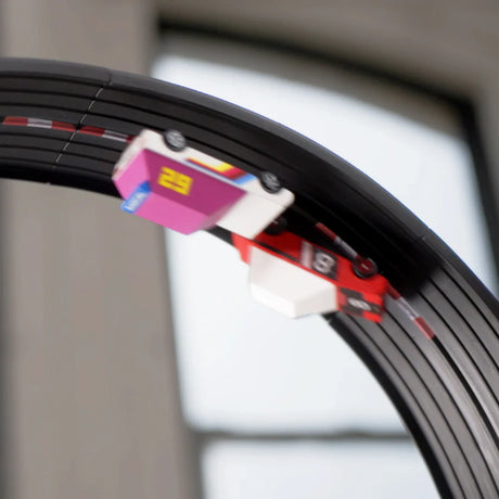 Action shot of Candylab toy cars racing upside down on a black Roadworks Loop track add-on kit.