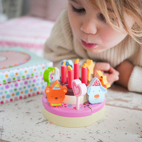 Wooden birthday cake toy for toddlers with toy candles and animal characters.