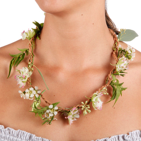 A woman wearing a DIY fresh flower necklace with pink and white blooms woven into a natural jute rope cord.