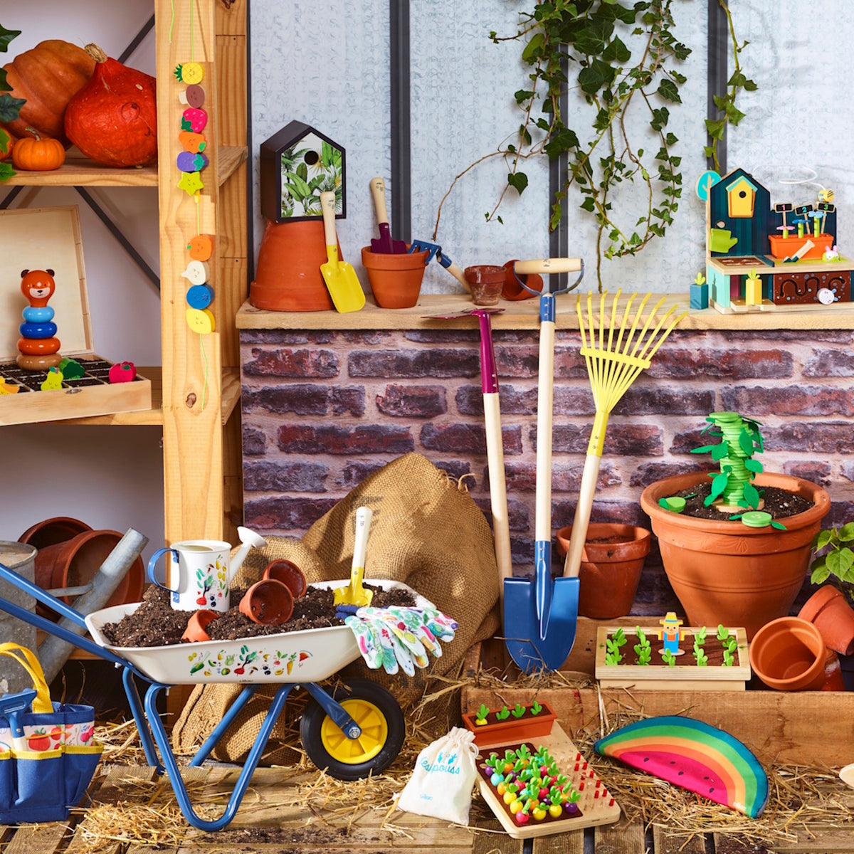 Vilac colorful kids' garden tools, wheelbarrow, and wooden toys displayed against a brick wall and rustic wooden shelves.