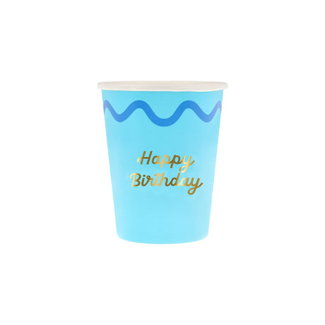 A light blue paper cup with a dark blue wavy line and "Happy Birthday" written in gold script.