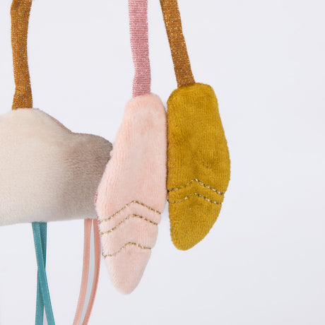 Close-up of plush baby toy charms: a cream cloud and two soft pink and yellow feathers with gold stitching.