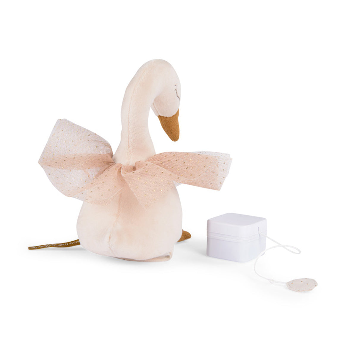 Soft plush swan toy with a glittery pink tutu and golden beak, positioned beside a white music box. The scene conveys a whimsical and gentle feel.