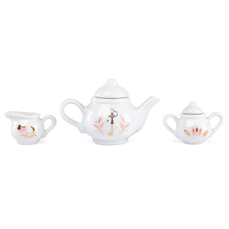 White ceramic miniature toy tea set with pink and gold key floral designs.