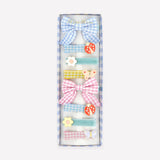 A box of eight assorted hair clips featuring gingham bows, velvet ribbons, ladybugs, flowers, and butterflies.