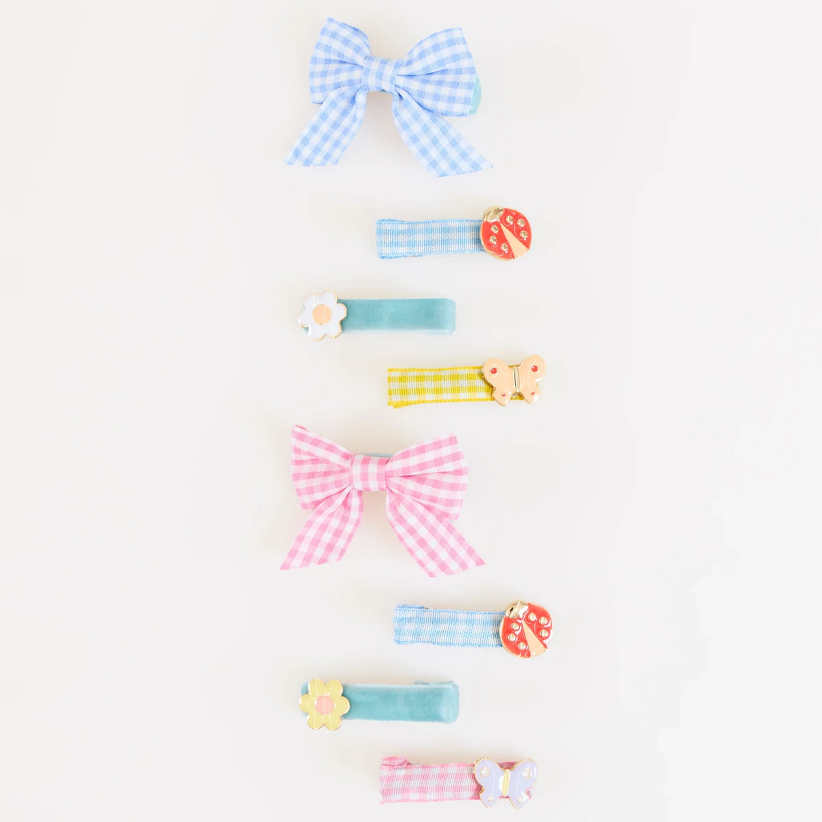 A vertical row of colorful gingham bows and fabric hair clips featuring ladybug, flower, and butterfly charms.