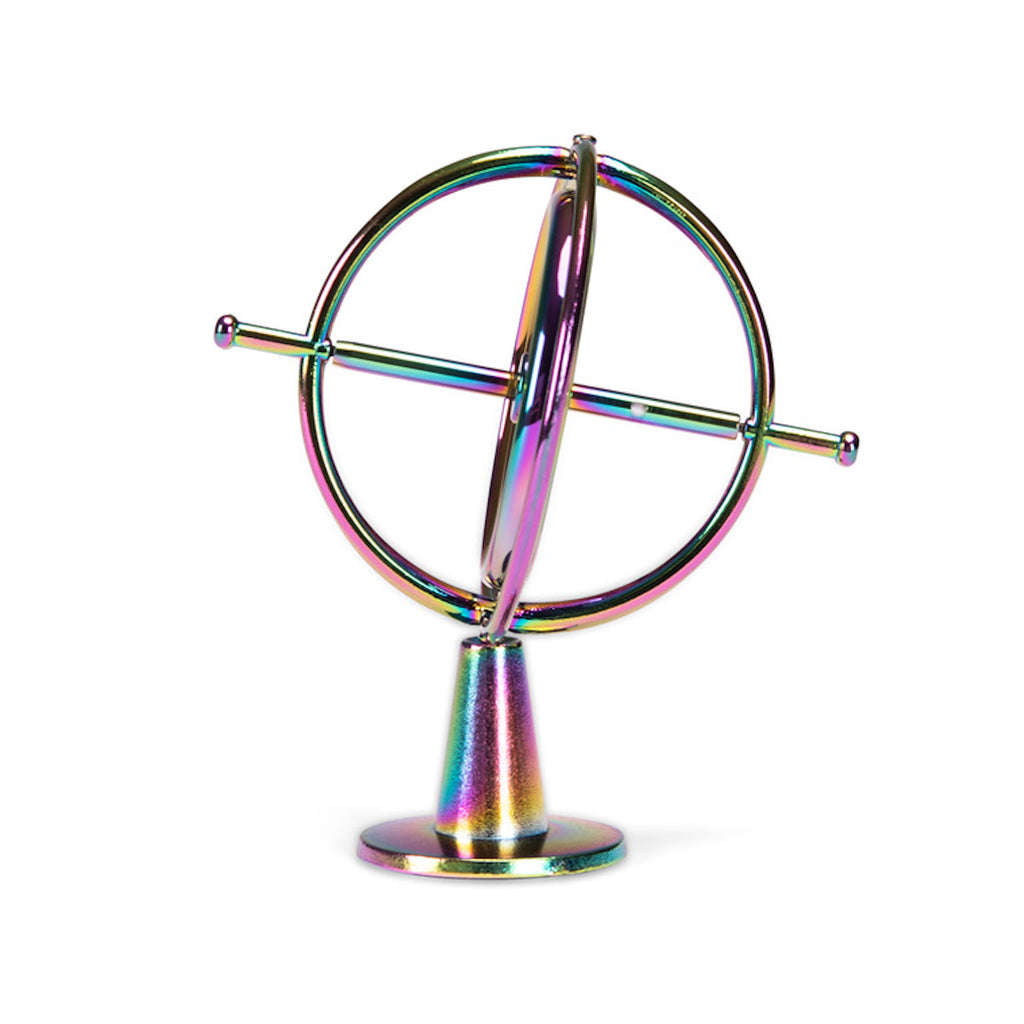 A metallic gyroscope with iridescent colors reflecting pink, blue, and gold hues. It features concentric rings and is set against a white background.