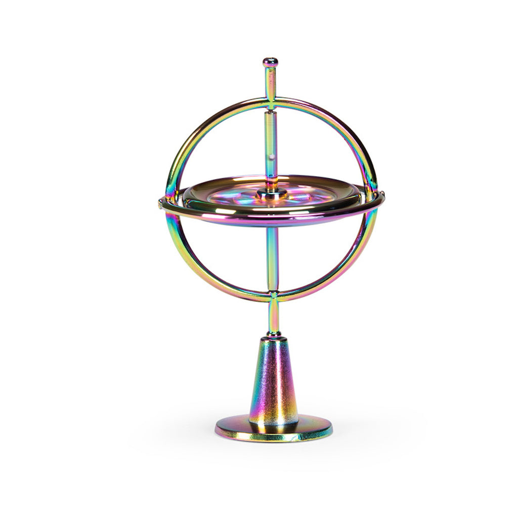 A metallic gyroscope with iridescent colors reflecting pink, blue, and gold hues. It features concentric rings and is set against a white background.