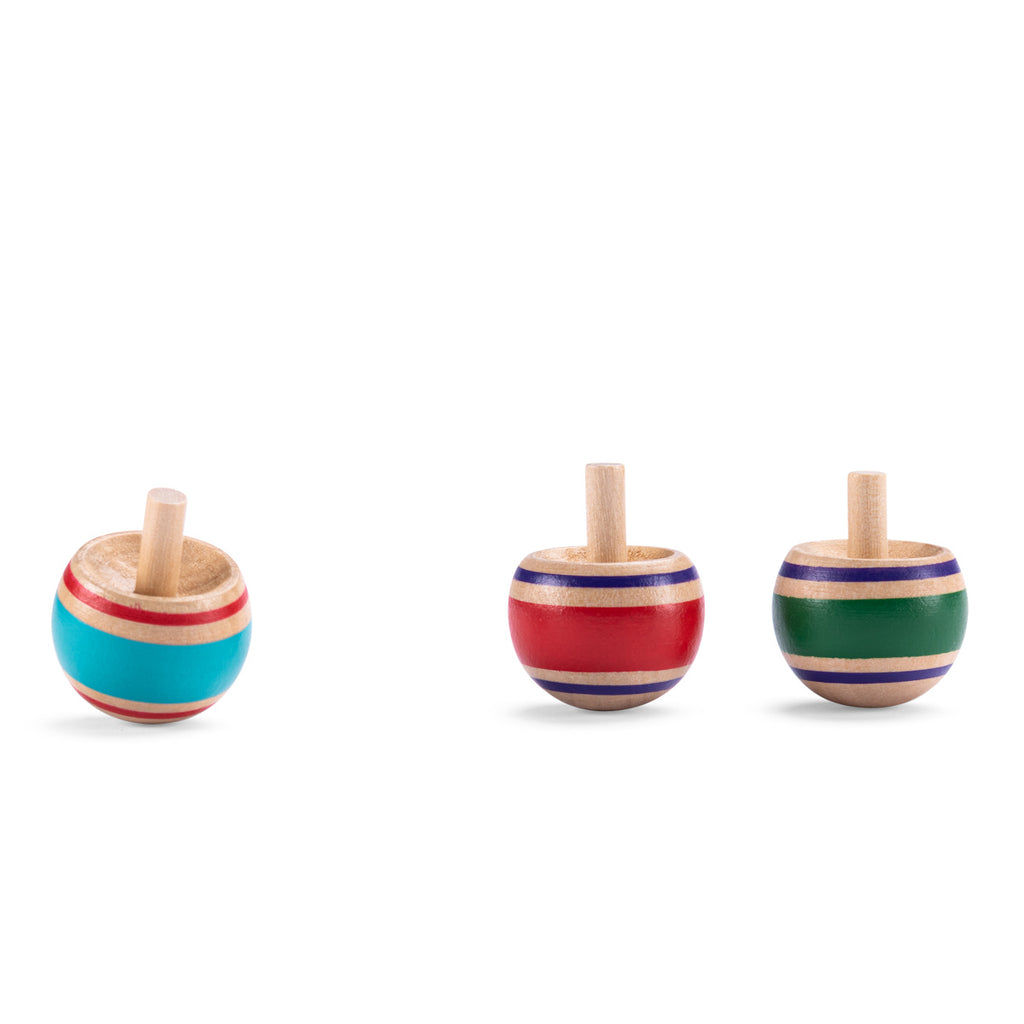 Three colorful wooden tops are arranged on a white background. Each top has a distinct color: blue, red, and green, with striped patterns.