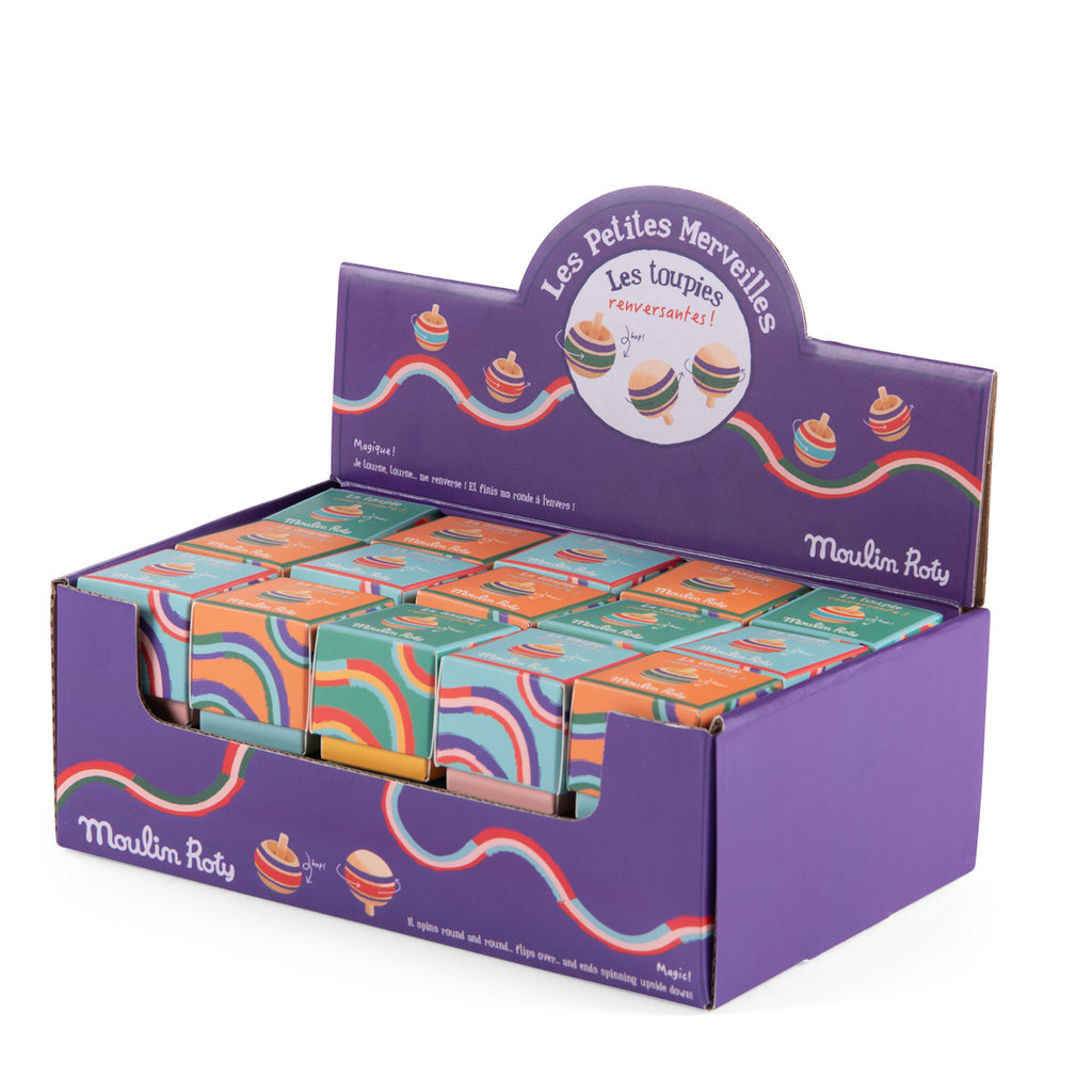 Box of colorful top toys from Moulin Roty, displayed in a vibrant purple case decorated with swirling rainbow patterns and playful top illustrations.