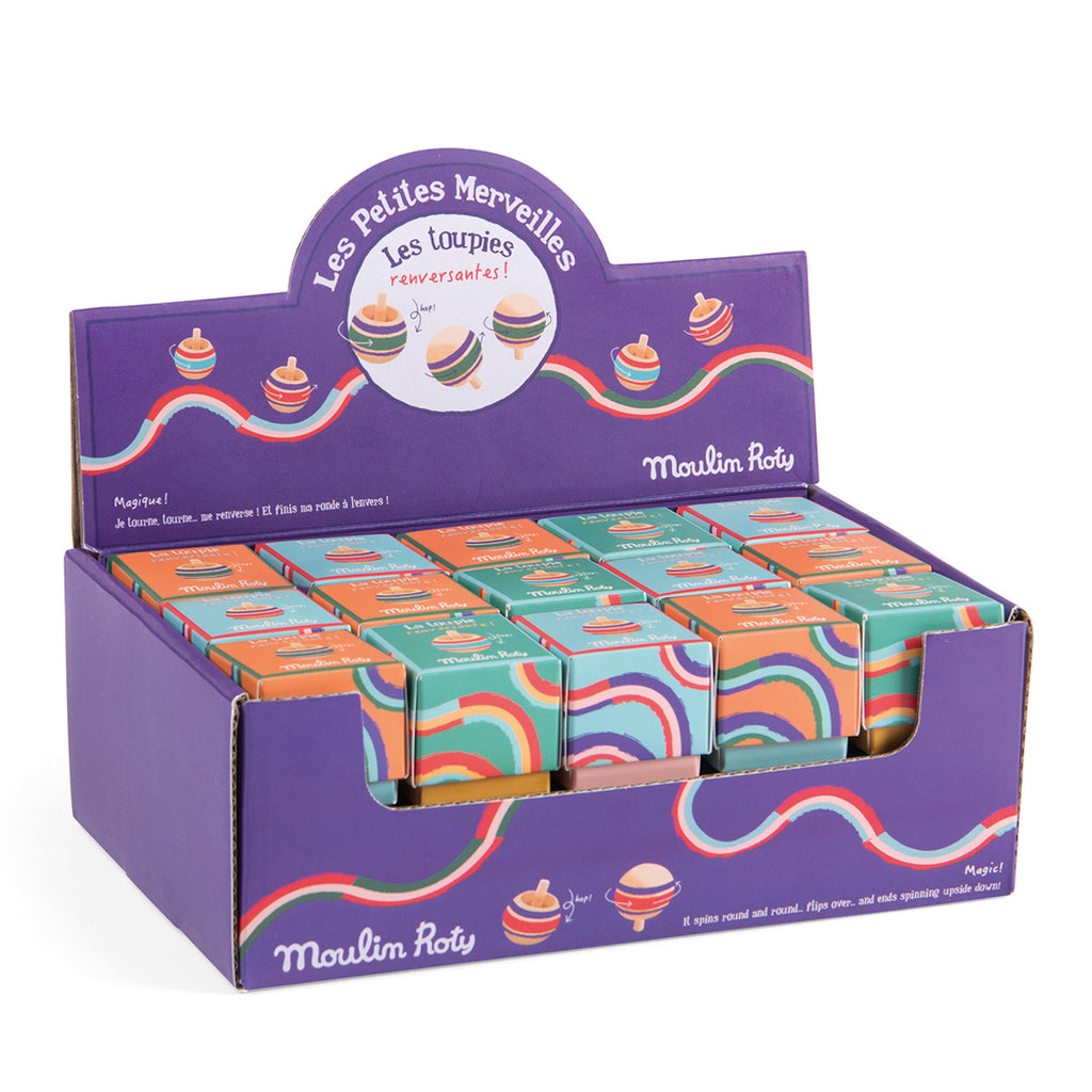 Box of colorful top toys from Moulin Roty, displayed in a vibrant purple case decorated with swirling rainbow patterns and playful top illustrations.