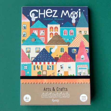 Colorful box of "Chez Moi Creative Stickers" on green background. Features vibrant, whimsical houses with patterns. Text reads "Arts & Crafts, 4+ Ages, Londji."