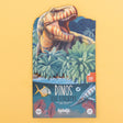 Sticker booklet with a colorful illustration of a roaring dinosaur amidst lush ferns and palms, set against a yellow background. Text reads, "Dinos 100 Stickers."