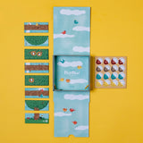 Londji Piu Piu counting board game with illustrated bird tiles, chick tokens, and sky-blue box on a yellow background.
