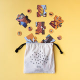 A flat lay of the Londji "We Want to Make a Better World" forest-themed memory game with jigsaw pieces and chips on yellow.