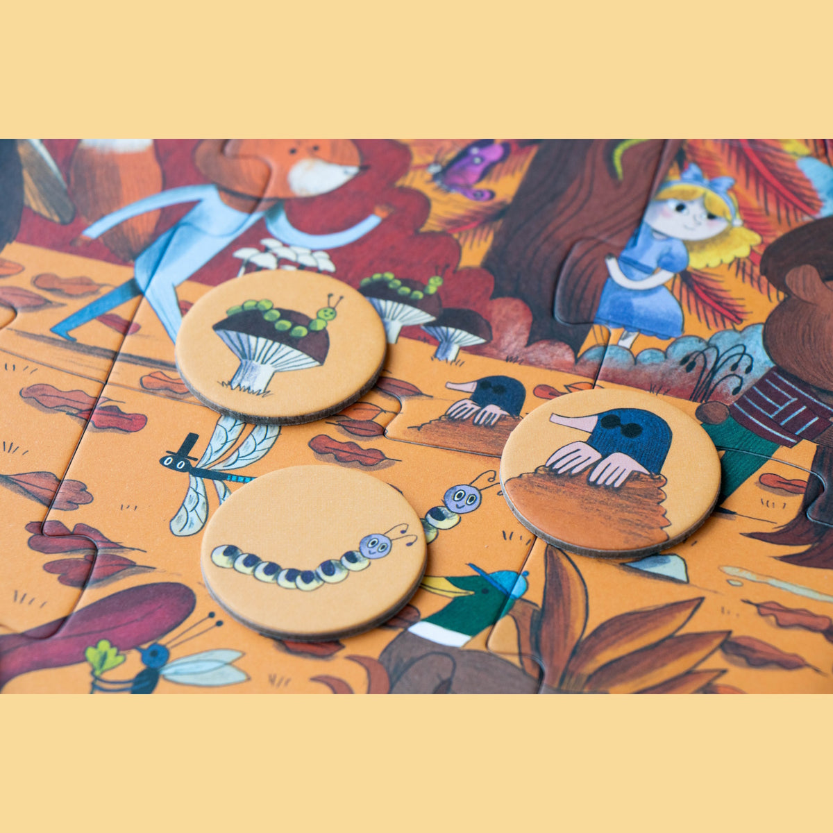 Londji forest jigsaw puzzle pieces with matching round tokens featuring a mole, caterpillar, and mushroom.