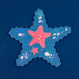 Starfish-shaped blue puzzle piece with red starfish illustrations, seashells, and coral on a dark blue background.
