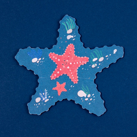 Starfish-shaped blue puzzle piece with red starfish illustrations, seashells, and coral on a dark blue background.