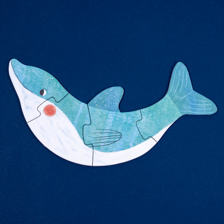 Whale-shaped Londji puzzle featuring a blue and white illustrated whale on a dark blue background.